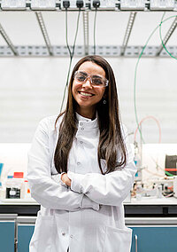 Forscherin mit weißem Kittel und Schutzbrille als Fachkraft für den Forschungsstandort Österreich